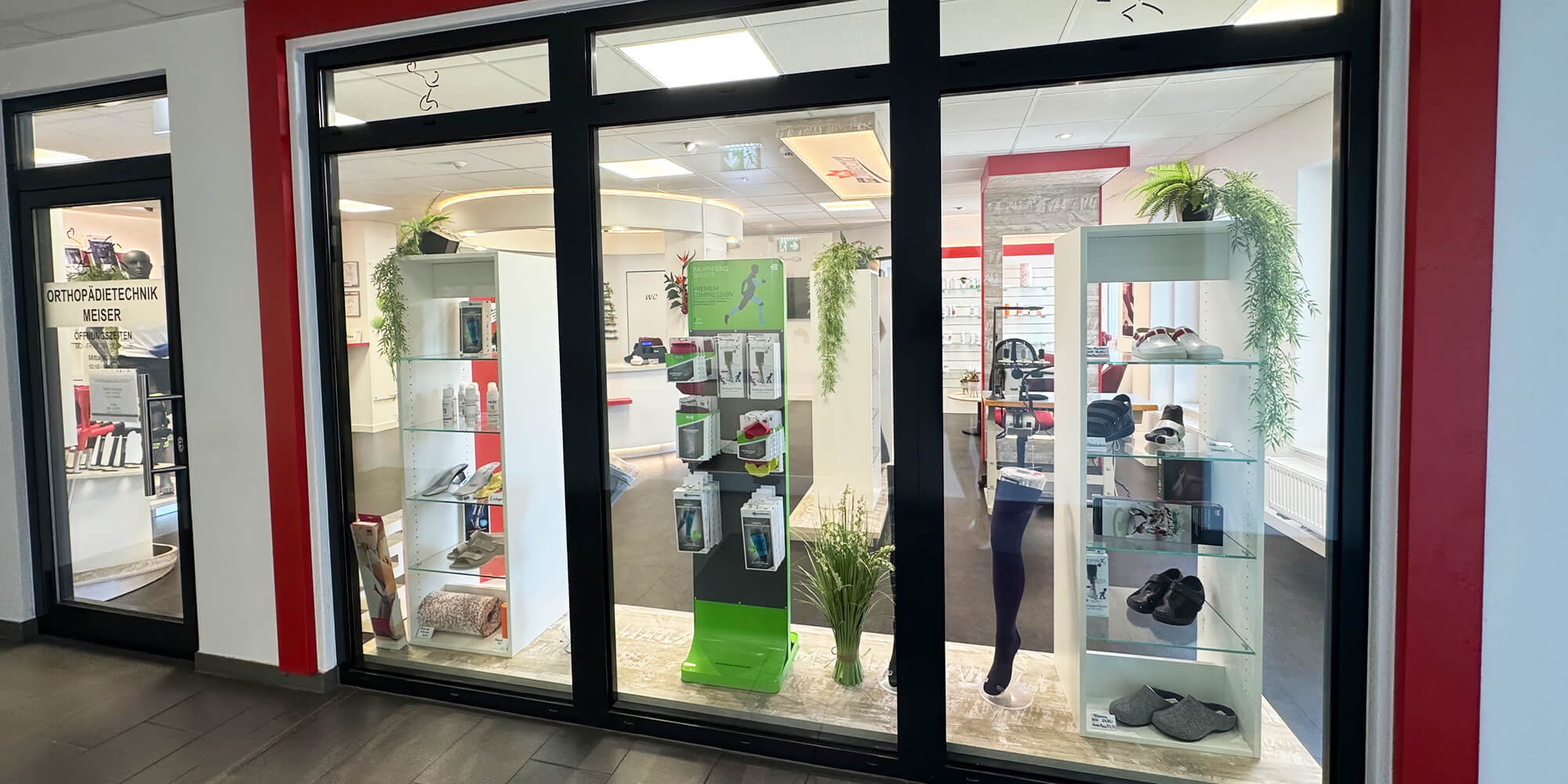 Außenansicht eines Sanitätshauses mit Glasfront und beleuchteten Produktvitrinen