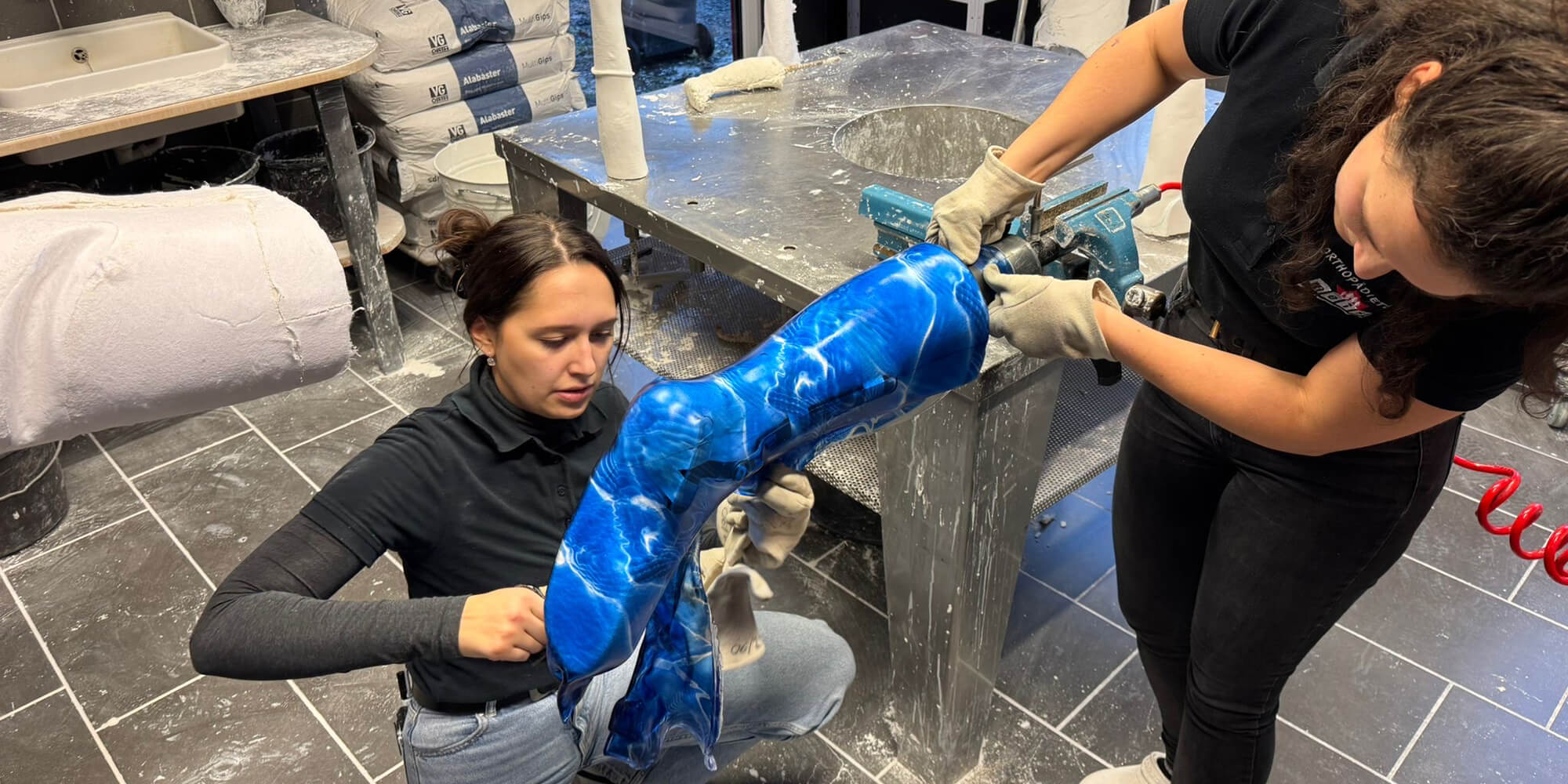 Orthopädietechnikerinnen fertigen eine individuell angepasste Beinorthese aus Kunststoff in der Werkstatt